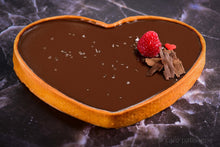 Load image into Gallery viewer, heart shaped dark chocolate tart with a raspberry on top

